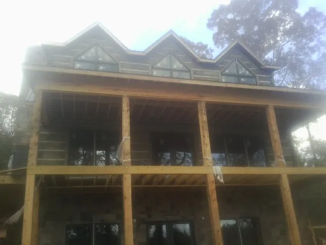 Dormers and porch framing on a large log home under construction in Hopkins